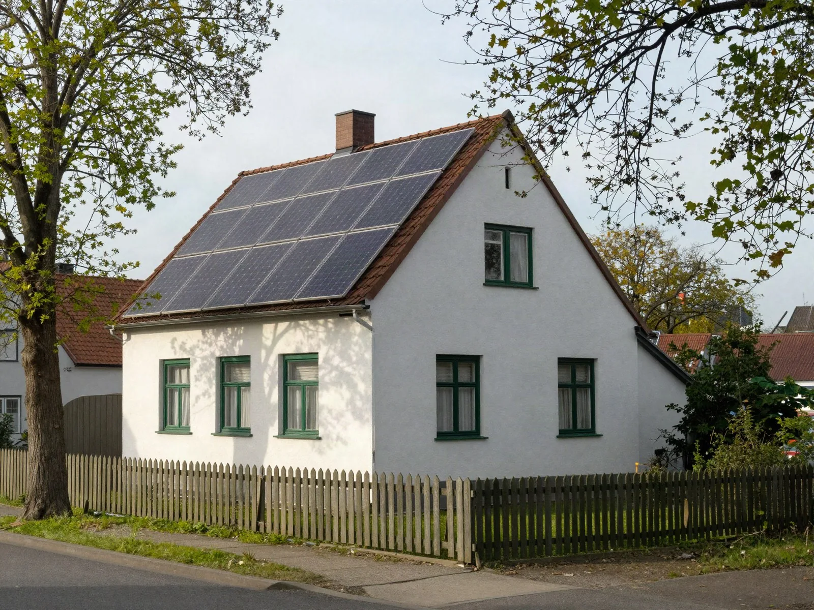Elektriker Oldenburg: Altbau mit Photovoltaik auf dem Dach in einer Wohnstraße